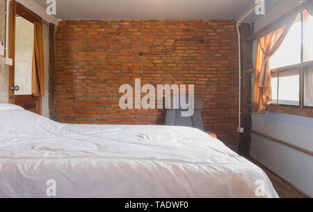 Lit blanc et fauteuil Design Intérieur Loft Pays de prix. Chambre design d'intérieur : porte et lit et fauteuil. Chambre design d'intérieur dans la partie de Banque D'Images