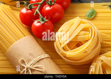 Composition avec des pâtes, des tomates et basilic sur fond de bois, gros plan Banque D'Images
