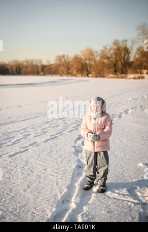 Portrait de petite fille debout sur le champ de neige Banque D'Images