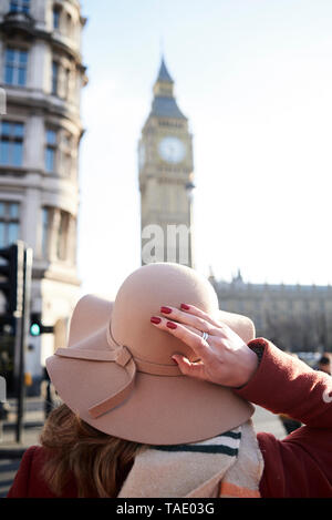 UK, Londres, vue arrière de femme portant un chapeau à la disquette à Big Ben Banque D'Images