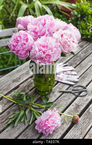 Bouquet de pivoines dans un vase sur la table de jardin Banque D'Images
