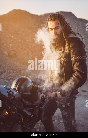 Portrait de motards barbus avec des dreadlocks fumeurs de cigarette électronique Banque D'Images