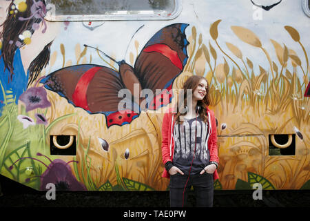 Smiling teenage Girl standing at a train voiture peinte Banque D'Images