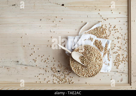 Le sarrasin biologique, grains entiers dans bast bol sur le bois, d'en haut Banque D'Images