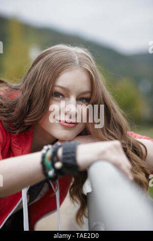 Portrait of teenage girl leaning on a railing Banque D'Images