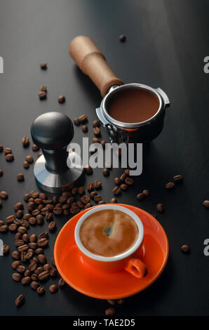 Tempera, titulaire, et l'orange avec une machine à espresso barista cup. Matériel pour la préparation du café fraîchement moulu. Banque D'Images