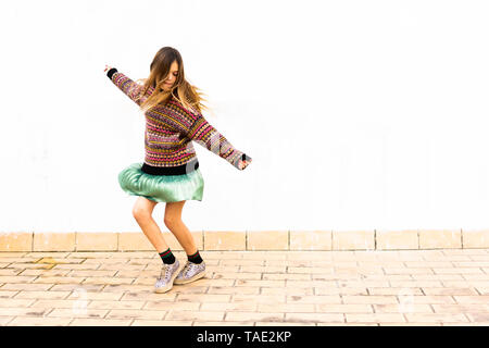 Girl Dancing in front of white wall Banque D'Images