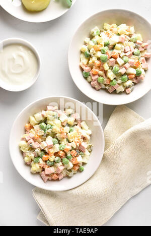 Savoureuse traditionnelle salade russe 'Olivier' à partir des légumes bouillis et des saucisses avec de la mayonnaise dans un bol. Noël ou Nouvel An Russe sur salade light bac Banque D'Images