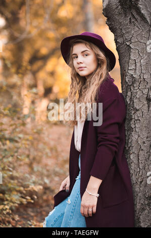 Belle fille de l'adolescence à 16 ans portant des vêtements automne élégante en parc. En regardant la caméra. Banque D'Images