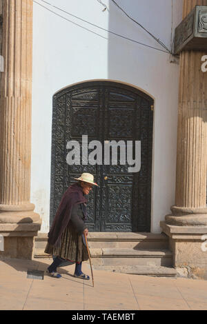 Vieille femme marchant avec une canne à l'époque coloniale Potosí, Bolivie Banque D'Images