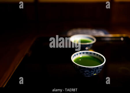 Tasses japonaises traditionnelles avec ou matcha thé vert mulberry dans ryokan avec table en bois laqué noir Banque D'Images