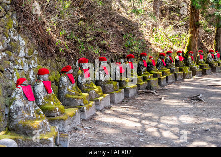 Statues Jizo rouge célèbre dans Kanmangafuchi Abyss, Nikko, Tochigi au Japon avec des bavoirs de nombreux chiffres protégeant les morts Banque D'Images