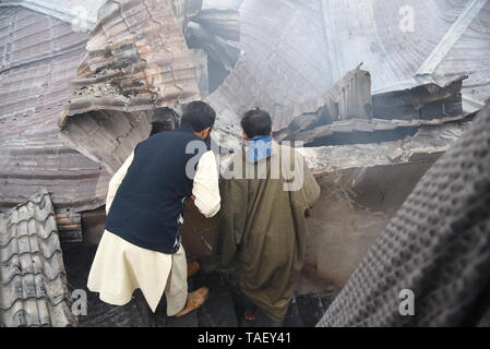 Les villageois du Cachemire sont vu l'inspection de maison ravagé par la guerre après une fusillade dans la région de Pulwama, au sud de Srinagar. Zakir Rashid Bhat Musa Alias a été tué jeudi par les forces de sécurité dans le district de Pulwama lorsque les forces de sécurité ont lancé une opération de bouclage et de ratissage dans Dadsara village de la zone centrale, au sud de Srinagar à la suite d'informations sur la présence de militants. Banque D'Images