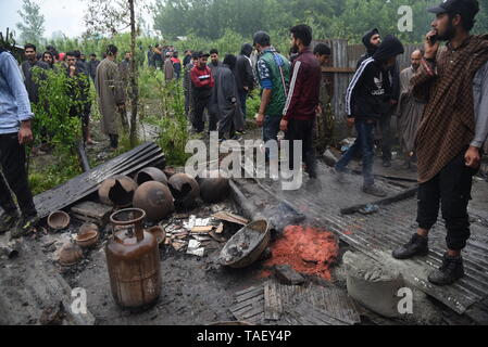 Les villageois du Cachemire sont vu l'inspection de maison ravagé par la guerre après une fusillade dans la région de Pulwama, au sud de Srinagar. Zakir Rashid Bhat Musa Alias a été tué jeudi par les forces de sécurité dans le district de Pulwama lorsque les forces de sécurité ont lancé une opération de bouclage et de ratissage dans Dadsara village de la zone centrale, au sud de Srinagar à la suite d'informations sur la présence de militants. Banque D'Images