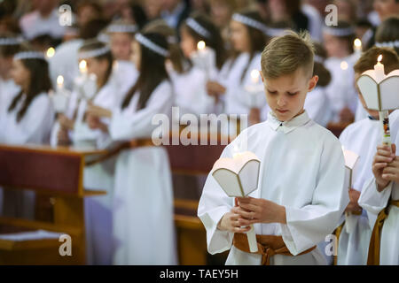 Zagreb, Croatie - Mai 11, 2019 : un jeune garçon tenant cierge allumé au cours de sa messe de première communion dans l'église Saint Nikola évêque de Zagreb, Croa Banque D'Images