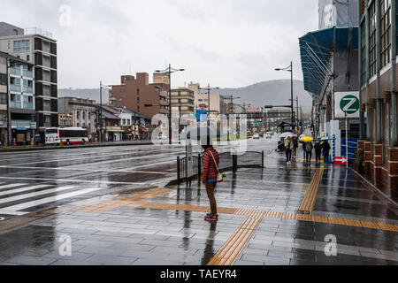 Kyoto, Japon - 9 Avril 2019 : Gojo-dori près du quartier de Gion jour nuageux pluie et par personne avec parapluie on sidewalk Banque D'Images