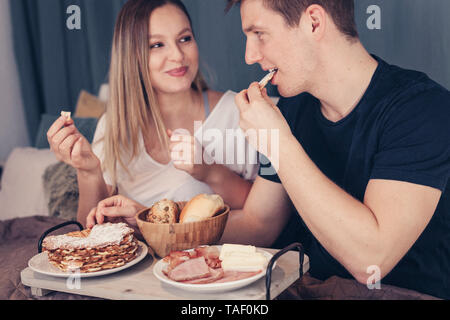 Young couple having breakfast in bed Banque D'Images