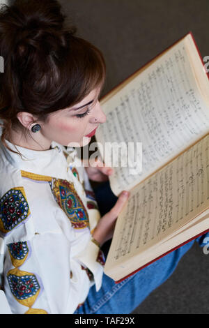 Female student reading book dans une bibliothèque publique Banque D'Images