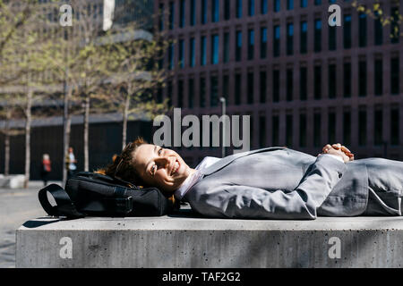 Young businesswoman with red shoes, reposant sur un banc de la ville Banque D'Images