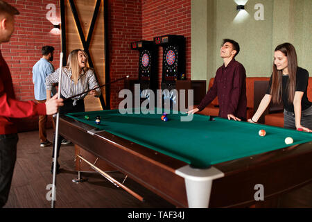 Happy friends playing billiards ensemble Banque D'Images