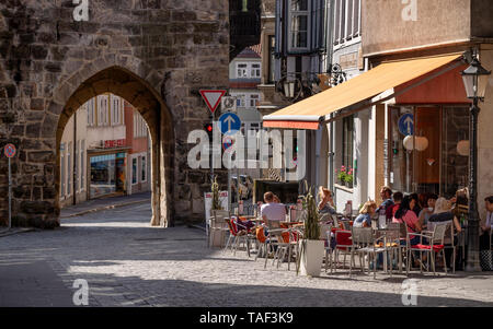 Café dans la zone piétonne à côté de 'Judentor', une des portes de la vieille ville de Coburg, Allemagne Banque D'Images