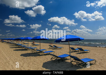 Des parasols et des chaises de bronzage bleu installé sur la plage. Banque D'Images