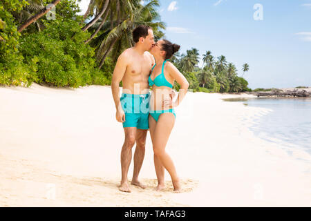 Jeune couple Standing On Beach embrassant près de la côte Banque D'Images