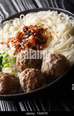 Bakso meatball indonésien est servi avec des nouilles, servi avec oignons caramélisés et les herbes sur une plaque verticale sur la table. Banque D'Images