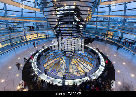 Les touristes à l'intérieur du dôme de verre futuriste sur le dessus du Reichstag (Parlement allemand) à Berlin, en Allemagne, dans la soirée. Banque D'Images