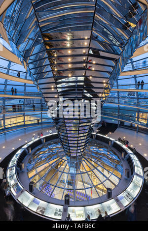 Les touristes à l'intérieur du dôme de verre futuriste sur le dessus du Reichstag (Parlement allemand) à Berlin, en Allemagne, dans la soirée. Banque D'Images
