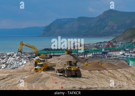 West Bay, Dorset, UK. 24 mai 2019. Photo un projet de plusieurs millions de livres de défense côtière étant construit avec des milliers de tonnes de rochers étant creusé dans la banque de la plage de galets qui protège le village balnéaire de West Bay dans le Dorset et devrait être terminé à la mi-juillet. Deux des principales plages sont fermées pendant la période de construction. West Bay a été le cadre de la détective ITV Broadchurch drame qui s'est présenté à trois séries. Credit : Graham Hunt/Alamy Live News Banque D'Images