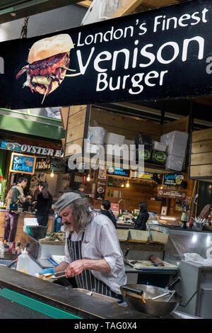 VENISON BURGER Borough Market célèbre venaison nouveauté éthique Décrochage Burger de caractère exposant la préparation d'une faible teneur en matières grasses de venaison fraîche saine burger snack-London UK Banque D'Images