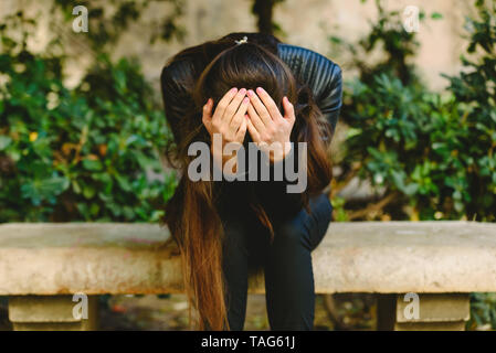 Jeune femme tenant enfoncé la tête dans les mains se sentir blessé contrariée, triste d'avoir des traumatismes psychologiques. Banque D'Images