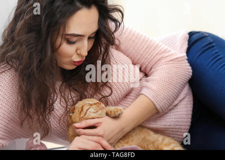 Jeune femme avec mignon chat drôle à la maison Banque D'Images