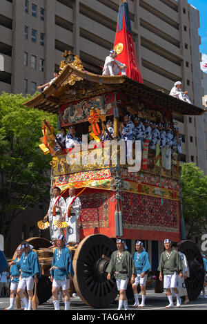 Festival de Gion Matsuri, le plus célèbre des festivals au Japon. Les participants en costume traditionnel tirant un énorme flotteur dans la parade. Banque D'Images