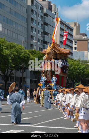 Festival de Gion Matsuri, le plus célèbre des festivals au Japon. Les participants en costume traditionnel tirant un énorme flotteur dans la parade. Banque D'Images