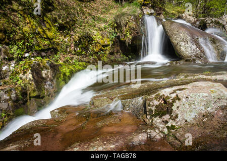 Scenic, longue exposition, cascade miniature sur un ruisseau de montagne au début du printemps, rouge, vif rocks Banque D'Images