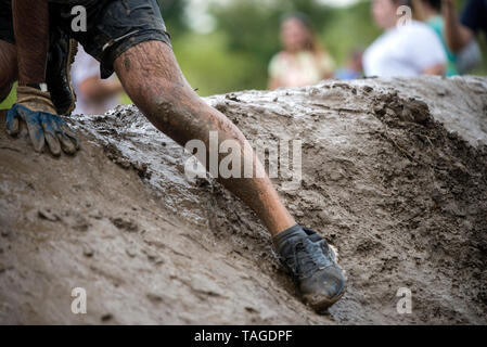 SOFIA, BULGARIE - 7 juillet 2018 - un mans jambe est glissant sur une pente boueuse dans le parcours d'une course de résistance. Banque D'Images