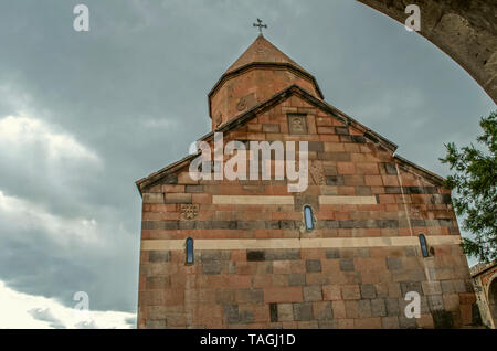 L'arrière de l'église médiévale de la Sainte Vierge avec croix sculptée sur le mur et le dôme à l'arrière-plan de pluie nuages dans le ciel Banque D'Images