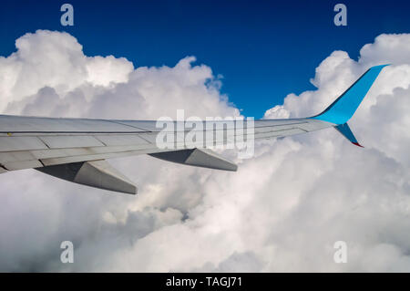 Ailes d'un avion dans un mélange de ciel ciel bleu et nuages Banque D'Images
