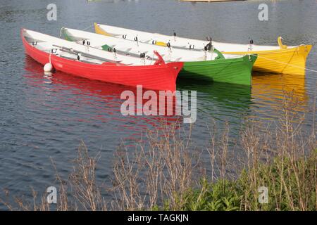 Barques en bois aux couleurs vives sur l'eau encore intégré Banque D'Images