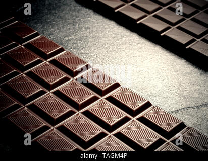 Deux barres de chocolat noir sur noir, vue du dessus de la plaque d'ardoise Banque D'Images