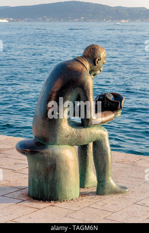 ZADAR, CROATIE - Juillet 10, 2016 : Sculpture d'un homme tenant un coquillage et regardant la mer Banque D'Images