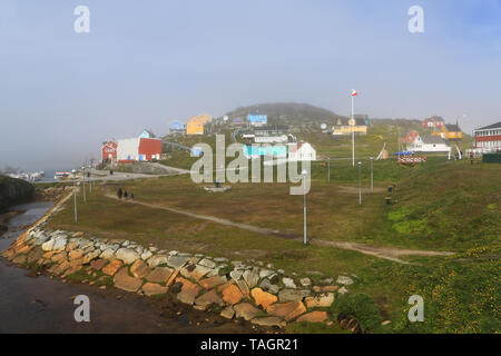 Vue générale des bâtiments et du ruisseau menant à la marina dans le village de Paamiut sur la côte ouest du Groenland. Banque D'Images