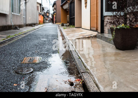 Quartier résidentiel de Kyoto au printemps avec la pluie flaque et pot de fleur personne n'en avril au Japon avec des gouttes sur la surface de l'eau Banque D'Images