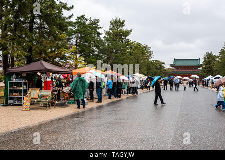 Kyoto, Japon - 10 Avril 2019 : Les gens avec des parasols au cours de jour de pluie en marche marché en parc d'Okazaki avec vue sur le Sanctuaire Heian Banque D'Images