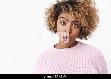 Vous dire ce que. Portrait d'élégant et charismatique cool africains-américains femme blonde avec les cheveux bouclés, bouche ouverte et soulever sourcil à drôle et Banque D'Images