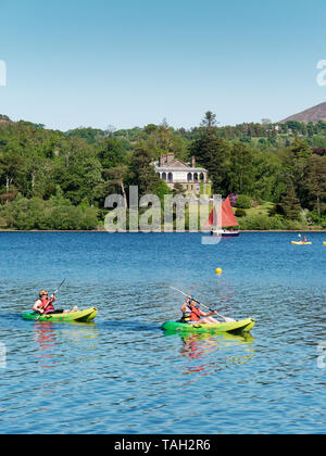 Un couple having fun in the sun avec leurs canots sur le lac Derwent Water dans le Lake District Banque D'Images