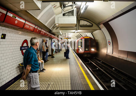 Tire un train de métro Bond Street en gare sur la ligne Central en tant que passagers se lever et attendre sur la plate-forme. Banque D'Images