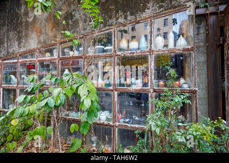 Vignes vert grimpant le mur d'un ancien atelier de céramique à Dafen. Shenzhen, province de Guangdong, en Chine. Banque D'Images